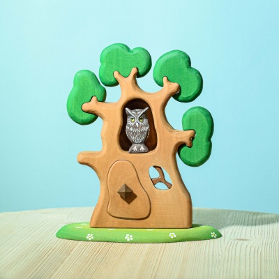 The treehouse incorporated into a sensory bin with natural materials like leaves, twigs, and pebbles.