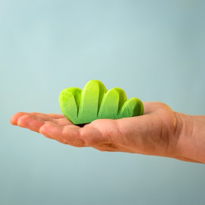 Hand holding the Lake Bush wooden toy.