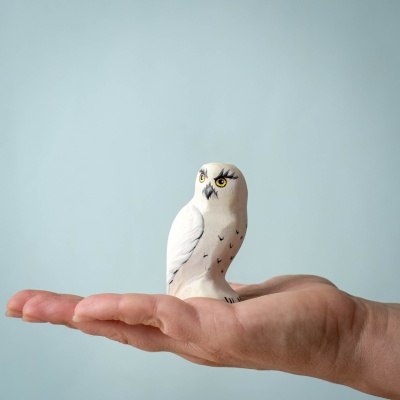 Hand holding the Snowy Owl toy, showcasing its compact and detailed design.