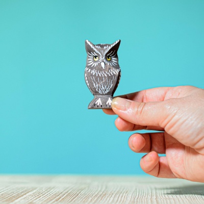 Image of a child holding the owl toy and pretending to fly it through the air.