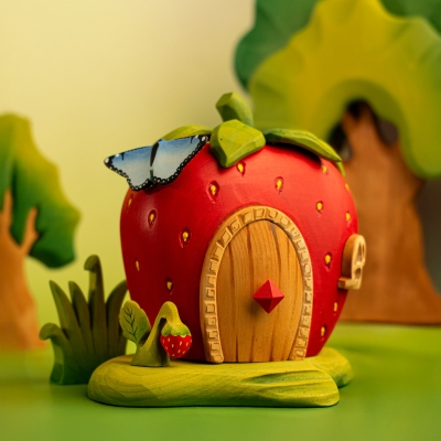 BumbuToys Strawberry House scene featuring the wooden Strawberry Plant in the foreground with a blue butterfly.