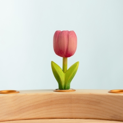 Close up of the handcrafted pink wooden toy tulip in a Waldorf celebration ring
