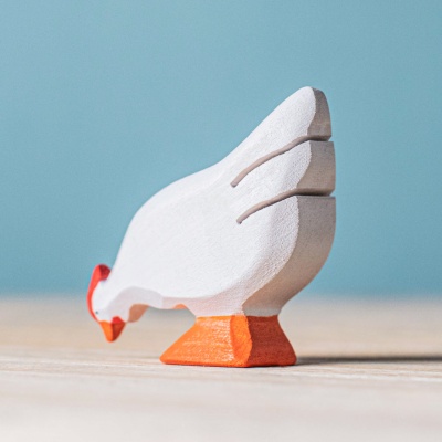 The BumbuToys White Hen being used in a pretend feeding or watering scene.