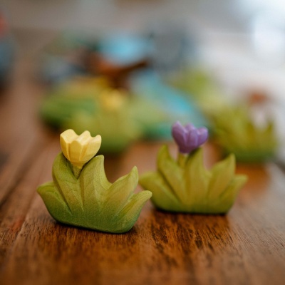 Child-safe wooden grass toy with LILA bloom.