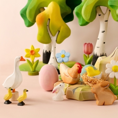 Wooden farm scene with goose, ducks, bunnies, hen, and a pink toy tulip under green trees
