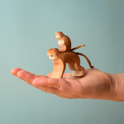 Hand holding the Monkey with Baby Monkey wooden toy.