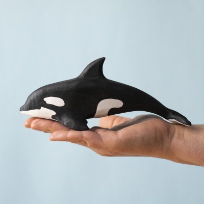 Hand holding the Orca toy, showing size and shape
