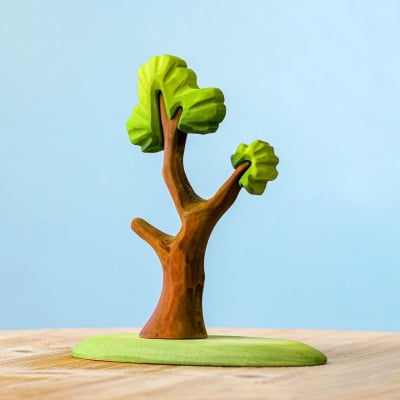 Hand-carved wooden tree toy on a wooden surface