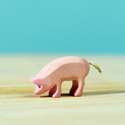 Wooden piglet eating, a charming detail of the BumbuToys Pig Family Set