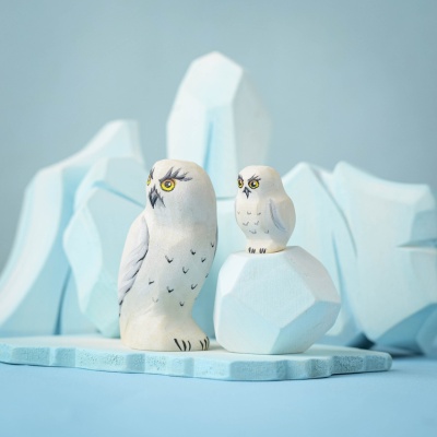 Snowy Owl and chick figurines displayed on icy-themed wooden blocks.