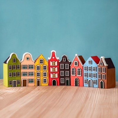 Row of eight colorful wooden European houses arranged on a wooden table.