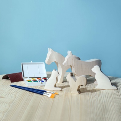 An assortment of unpainted wooden figures from BumbuToys' BLANK SET, ready for a splash of color and creativity.
