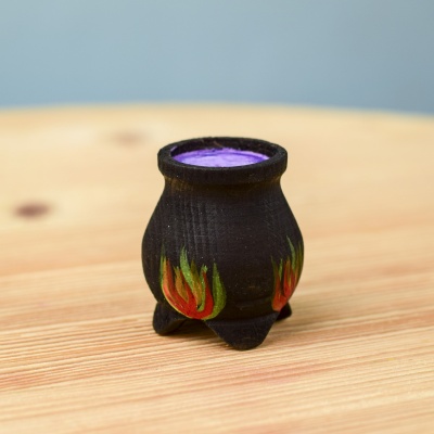 Handcrafted wooden cauldron on a wooden surface.