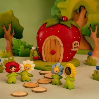 Collection of BumbuToys flower children including Daisy, Poppy, and Sunflower standing on a path in a small world scene.
