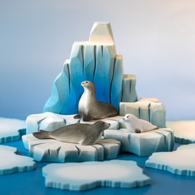 Montessori Arctic play scene with wooden icebergs, adult seal, and pup figures.