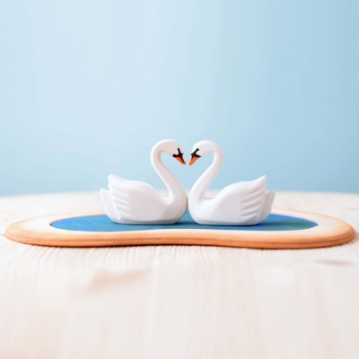 Handcrafted swan couple set against a serene wooden heart lake.