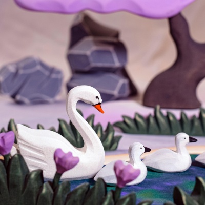 Elegant swans gracing a heart lake, a serene scene from Bumbu Toys.