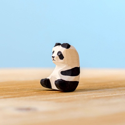 Side view of a wooden panda bear cub figurine with detailed painting