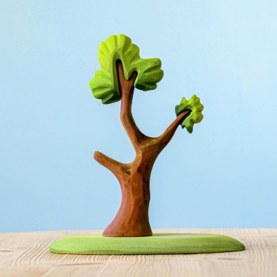 Side view of a wooden tree figurine with detailed painting