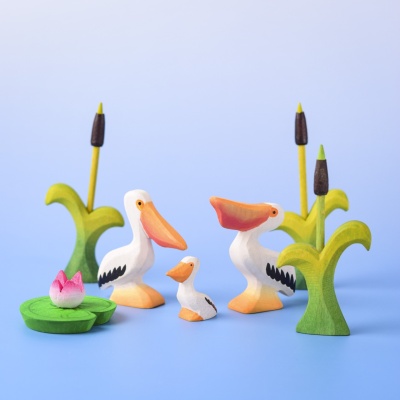 Pelican family scene including Pelican Eating, Pelican, and Pelican Chick figures surrounded by reeds and lily pad.