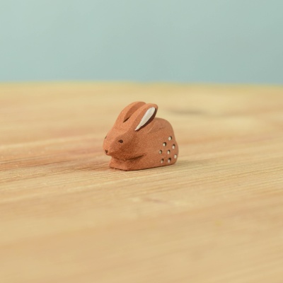 Handcrafted Perching Baby Rabbit figurine on a wooden surface