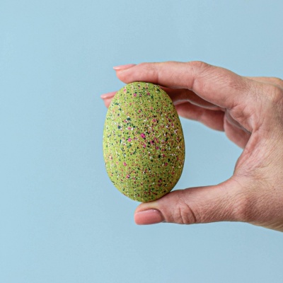A child's hands excitedly breaking open a T-Rex egg.