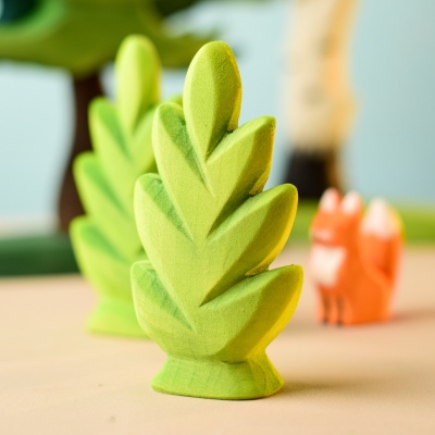 Thuja Shrub toy in a play scene with other wooden animals and plants.