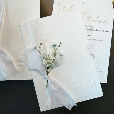 Invitație de nuntă albă cu fundă din voal și detalii aurii – model elegant personalizat