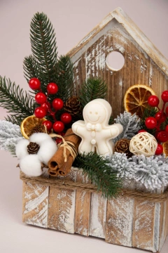Decorațiune rustică de Crăciun în căsuță din lemn, cu crenguțe de brad, bobițe roșii și elemente naturale