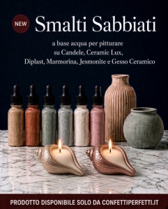 Smalti Sabbiati a base acqua: quattro portacandele a forma di conchiglia dipinti in oro champagne, oro rosa, oro rosso e oro azzurro con candele accese, accanto ai flaconi di smalto e vasi in gesso su piano in marmo. Prodotto disponibile su ConfettiPerfet