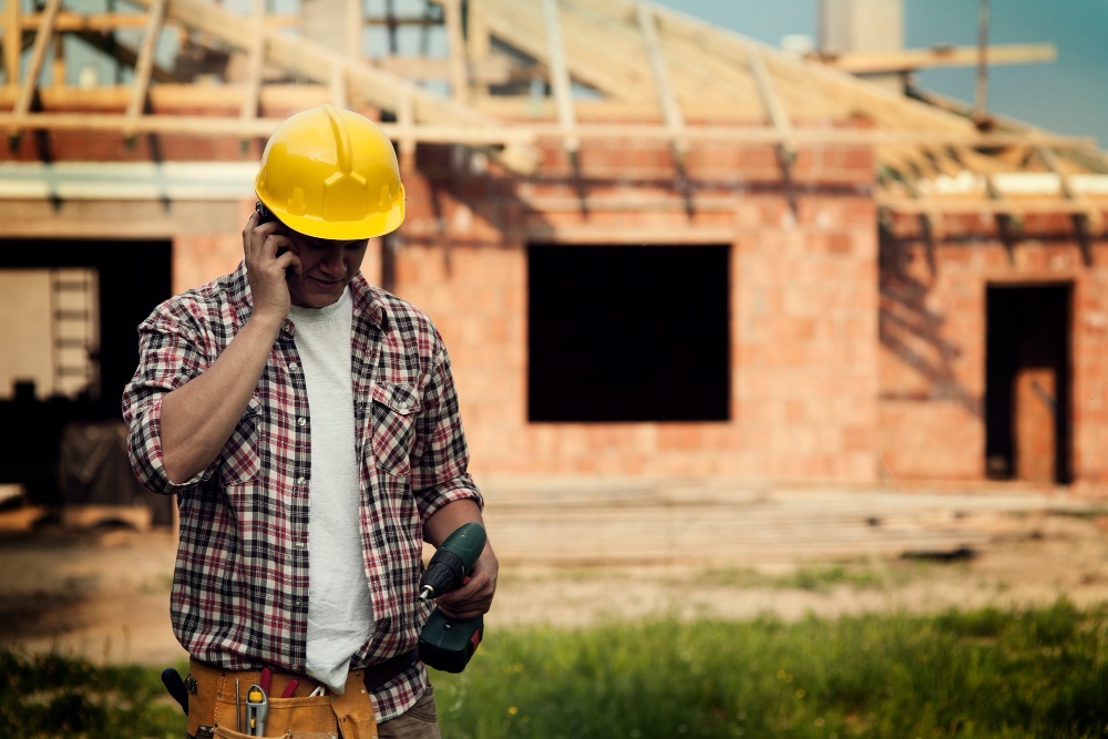 om care vorbeste la telefon langa o casa in constructie