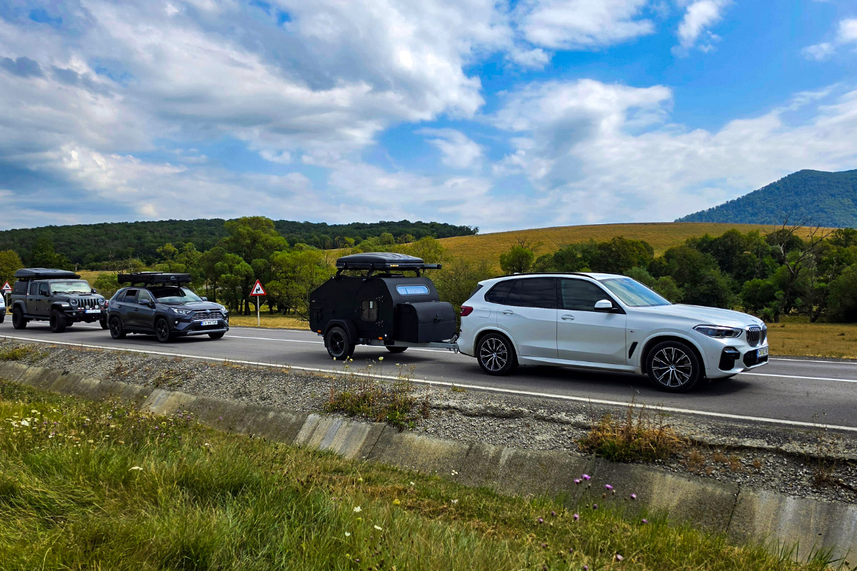 Convoi de SUV-uri și un camper pe drum