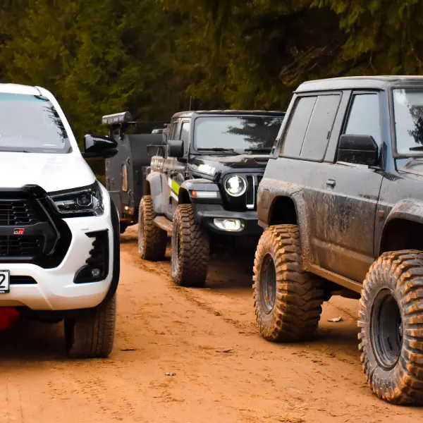 Anvelope off-road pe trei mașini 4x4, pe un drum de pământ