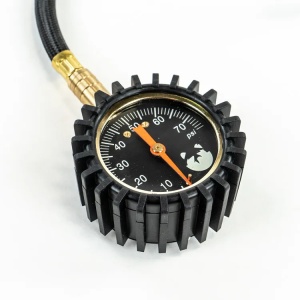 Manometrul analog cu cadran negru și ac indicator portocaliu.