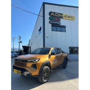 Vedere generală a automobilului Toyota Hilux (2026+) cu pragurile S32 AQM4WD, lângă clădire.