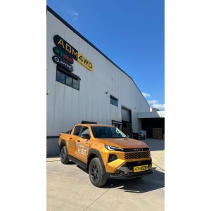Extinsă cu bara AQM-PST18 pe Toyota Hilux (2026+) lângă clădirea AQM4WD.