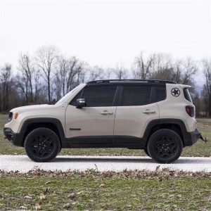 Profil lateral al unui Jeep Renegade cu suspensia liftată, pe teren accidentat.