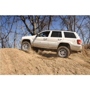 Jeep Grand Cherokee WJ WG echipat cu kitul de suspensie Rough Country, în teren accidentat.
