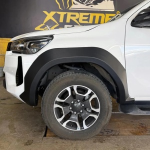 Prim-plan cu overfenderul frontal montat pe aripa unui Toyota Hilux.