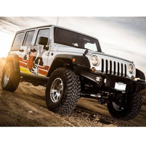 Amortizorul de direcție FOX montat pe un Jeep Wrangler JK în teren accidentat.
