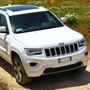 Vedere frontală a unui Jeep Grand Cherokee WK2 (2014-2022) alb, vehiculul compatibil.