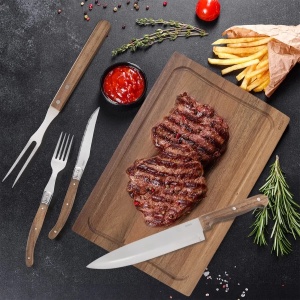 Setul steak 15 piese Orion prezentat în uz, cu fripturi pe tocătorul din lemn de salcâm, Set steak 15 piese.