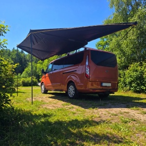 Marchiza CampTalk deschisă, montată pe mașină, într-un cadru natural.