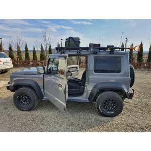 Vedere laterală a Jimny-ului echipat cu bara spate și portbagaj de plafon.
