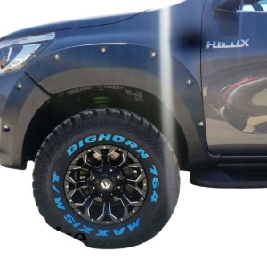 Prim-plan cu overfenderul Kut Snake de 7.5cm pe roata față a unui Hilux Revo.