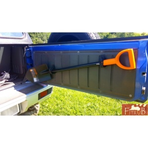 Lopată mare fixată cu cleme pe ușa din spate a unui vehicul 4x4.