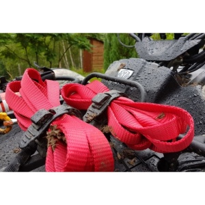 Clemele universale montate pe un ATV, fixând curele de prindere în condiții de noroi.