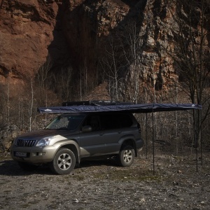 Marchiza Overlander montată pe acoperișul unui SUV, gata de camping.