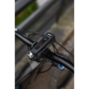 Lampa frontală montată pe ghidonul unei biciclete, cu indicatorul de baterie.