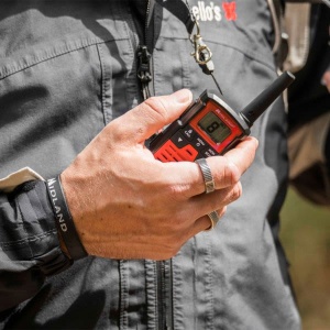 Stația PMR Midland XT10 PRO utilizată, ținută în mână de un utilizator.